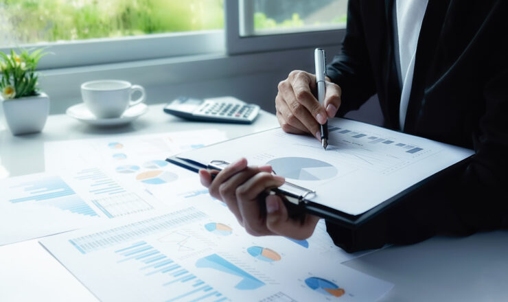 Asian business woman analyzing investment charts on desk. Vintage tone Retro filter effect,soft focus,low light.(selective focus).