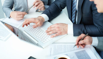 Group of business people working with laptop at meeting